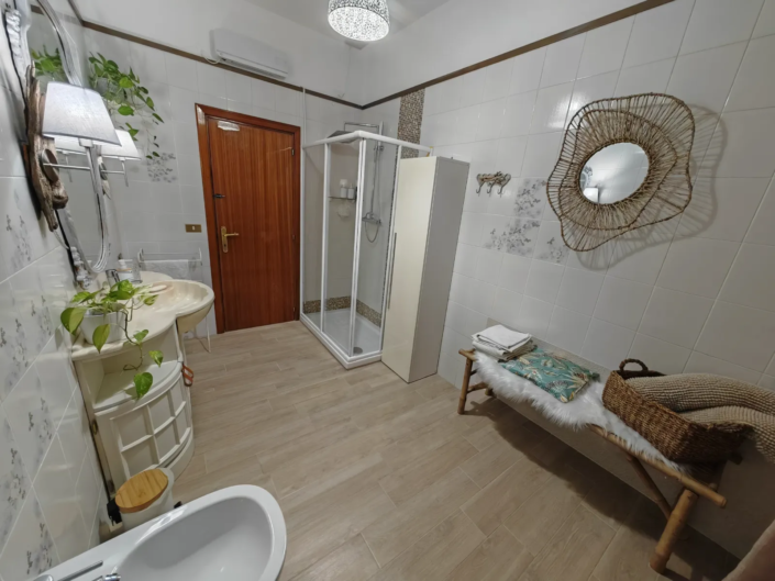 Bagno luminoso con doccia, panca e specchio decorativo, casa vacanze Verdeacquassisi ad Assisi