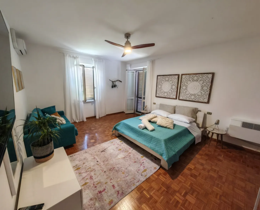 Camera LUCE con letto matrimoniale, divano e tappeto, casa vacanze Verdeacquassisi ad Assisi