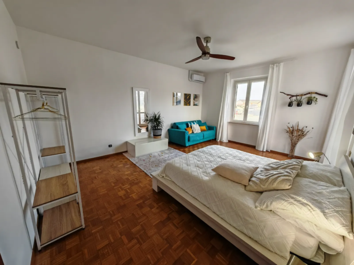 Camera LUCE con letto matrimoniale, divano e parquet, casa vacanze Verdeacquassisi ad Assisi