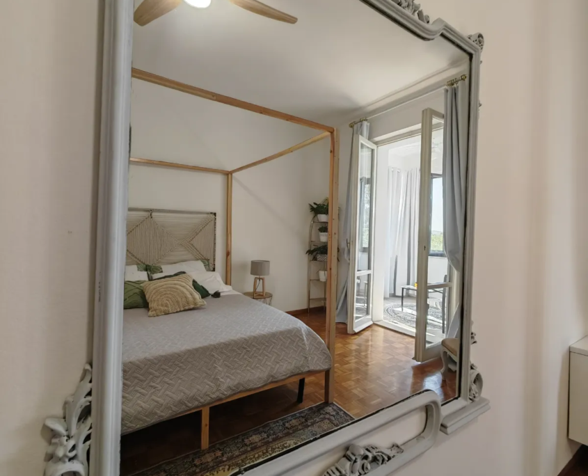 Specchio decorato che riflette il letto a baldacchino della camera PACE, casa vacanze Verdeacquassisi ad Assisi