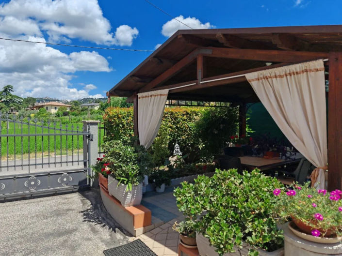 Gazebo con tende e piante nel giardino privato, casa vacanze Verdeacquassisi ad Assisi