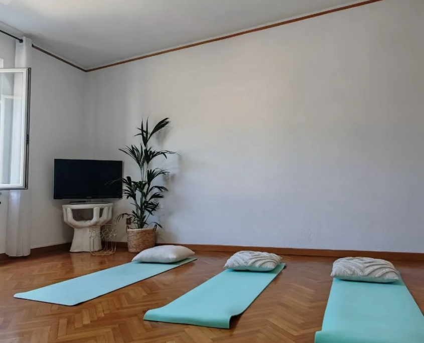 Sala ENERGIA con tappetini per yoga e meditazione su parquet, casa vacanze Verdeacquassisi ad Assisi