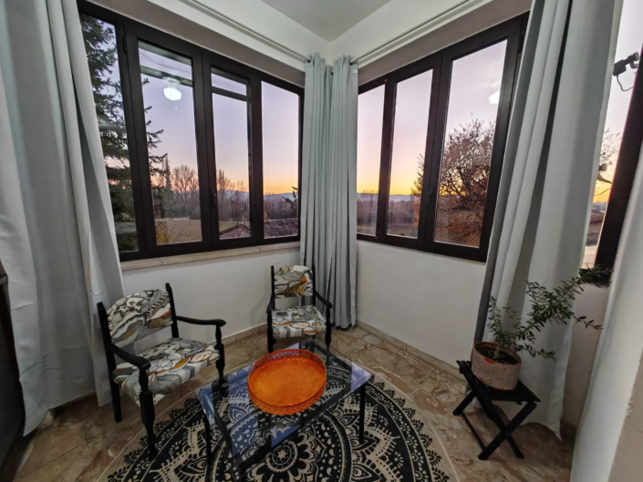 Sala relax con vetrate panoramiche al tramonto, casa vacanze Verdeacquassisi ad Assisi
