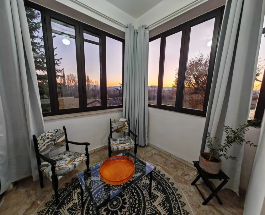 Sala relax con vetrate panoramiche al tramonto, casa vacanze Verdeacquassisi ad Assisi