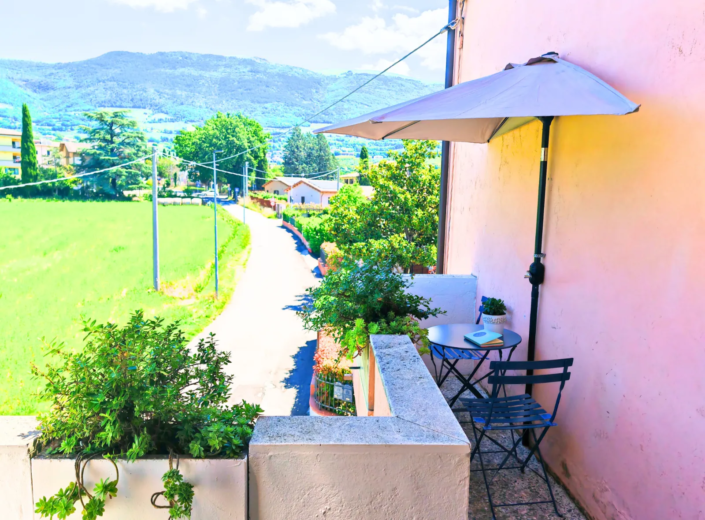 Terrazzo con tavolino, ombrellone e vista sulle colline, casa vacanze Verdeacquassisi ad Assisi