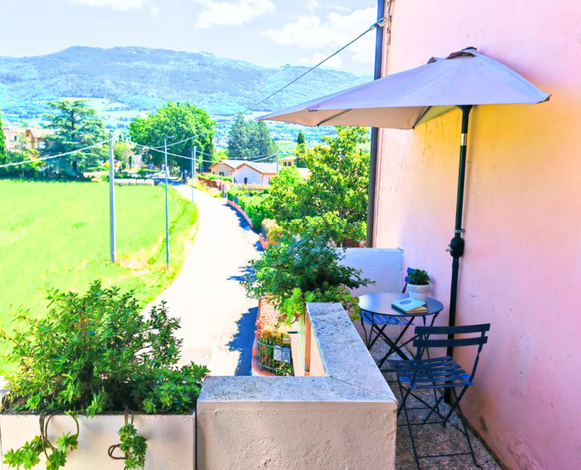 Terrazzo con tavolino, ombrellone e vista sulle colline, casa vacanze Verdeacquassisi ad Assisi