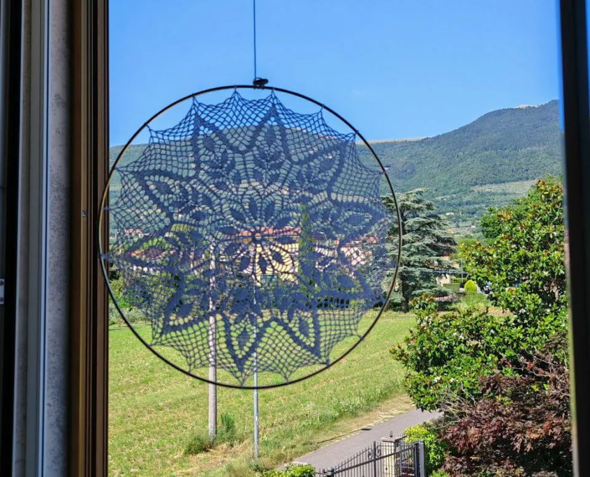 Vista dalla finestra sulle colline umbre con mandala decorativo, casa vacanze Verdeacquassisi ad Assisi